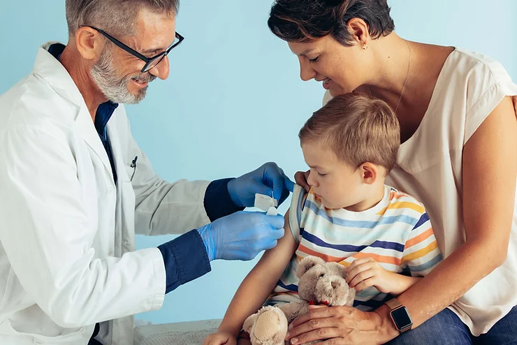 Small boy receiving a vaccine from a healthcare professional
