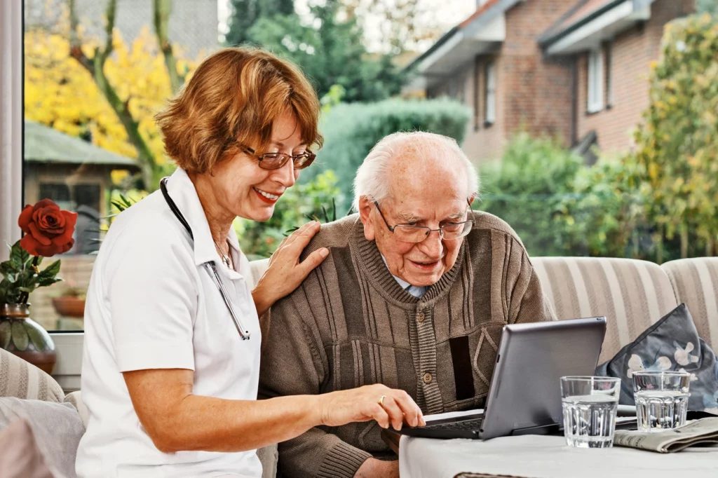 Certified Home Health Aide helping a patient on the computer