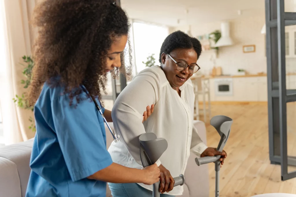 Patient Care Technician assisting a patient to ambulate